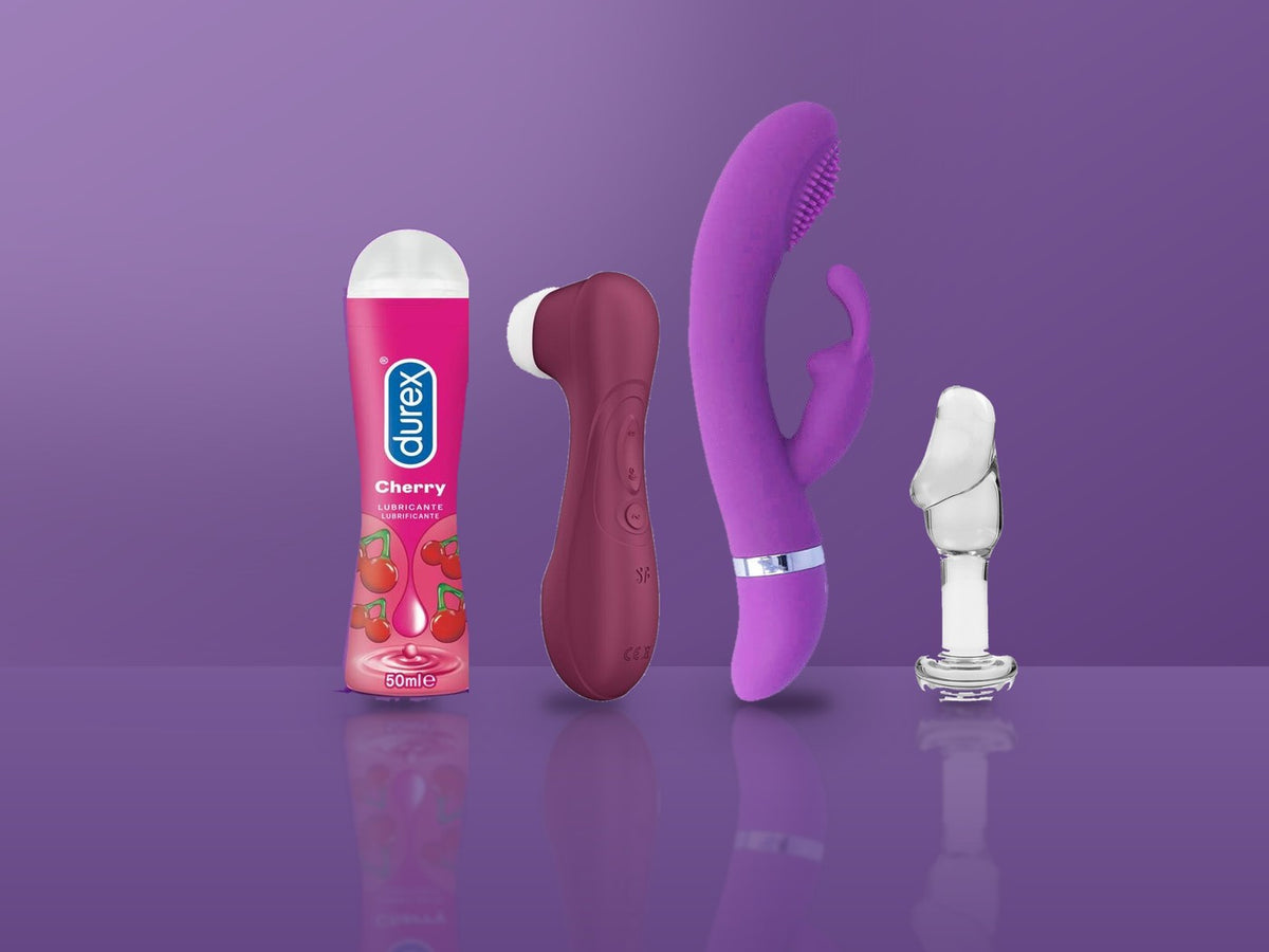 Lubrifiant Durex, stimulateur Satisfyer, vibromasseur rabbit et plug en verre alignés sur fond violet