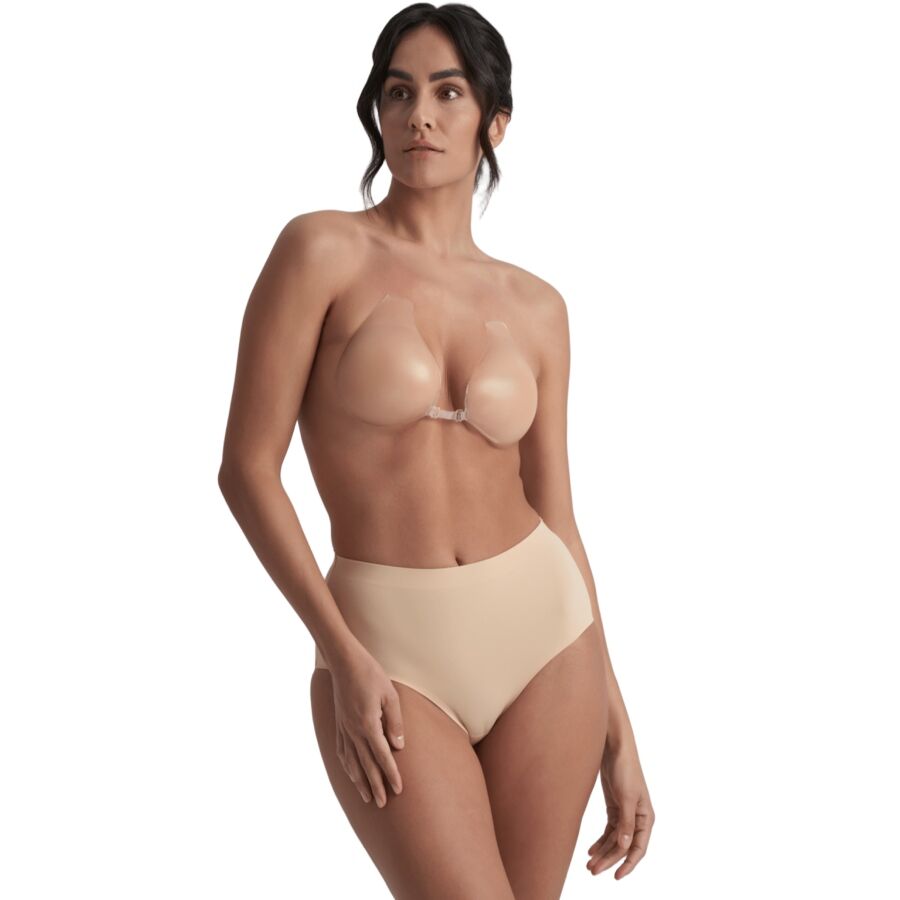 Bonnets adhésifs Bye Bra en silicone beige portés avec clip central, vue de trois quarts