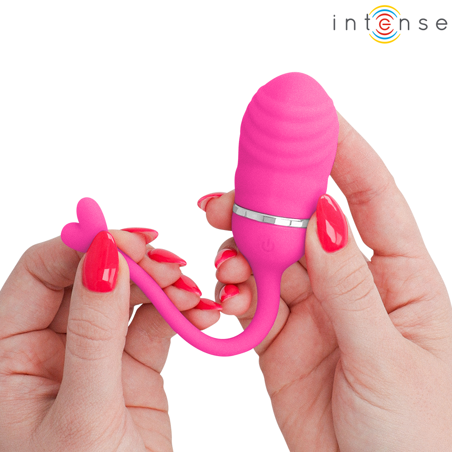 Œuf vibrant Sookie Intense rose tenu entre deux mains, queue en cœur